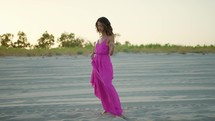 Dancing pink dresses Girl On The Beach near ocean at sunset