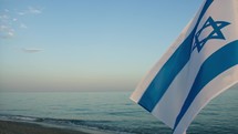 Israel Flag waving on the beach near the Sea