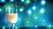 Sparkling wine glasses with disco lights in the background 