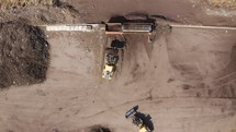 Aerial shot of an Industrial compost production site. Tractors loading compost into machines and trucks
