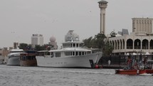 Large boats and yacht on old Dubai river with slow motion bird flying overhead. 