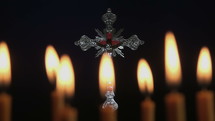 Small silver crucifix near lighting candle.
