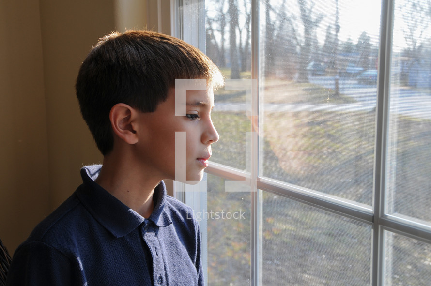 a boy looking out a window 