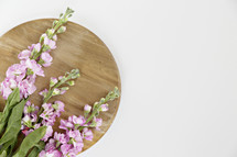 pink flowers on a wood cutting board 
