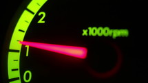 Detail of a speedometer in a car at night.