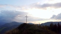 Aerial View of a Religious Christian Steel Cross on a Hill in the Mountainous Countryside
