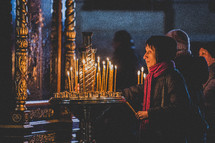 women lighting candles in a sanctuary 