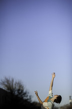 woman's arms raised to the sky