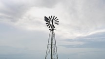 Windmill in farmland prairie grass in cinematic slow motion.