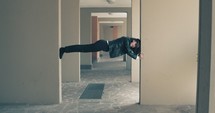 Woman holding herself up horizontally in a door frame.