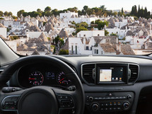View of a car dashboard with a navigation unit traveling to Alberobello