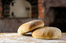 Two loaves of bread in rustic kitchen