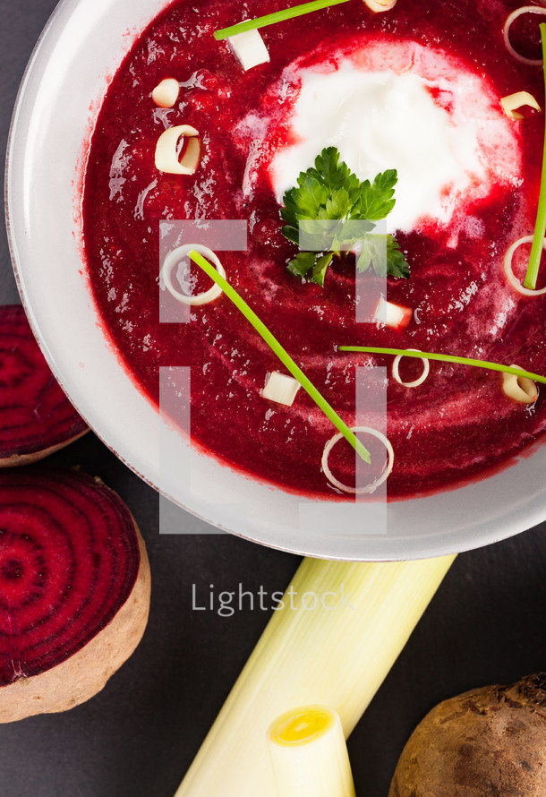 Beetroot, red borscht with sour cream and parsley.