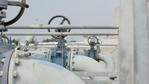Oil and gas pipes and valves at a large oil refinery.