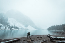 a couple standing beside Moraine lake in winter 