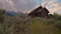 Old Wooden Chapel in the Mountains at Sunset