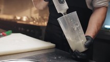 Cook uses immersion blender to prepare a sauce