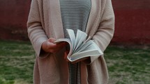 woman flipping through the pages of a Bible