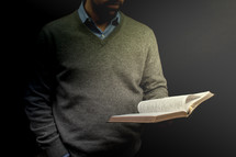 a preacher holding  a Bible during his sermon 