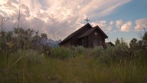 Old Wooden Chapel in the Mountains at Sunset