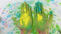 Hands Of Man Touching Holi Colored Powder On White