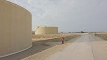 Large crude oil storage tanks in a huge refinery.