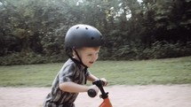 toddler boy riding a bike on a path