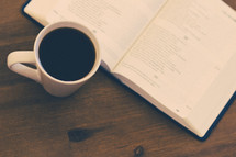 open Bible and coffee mug on a table 