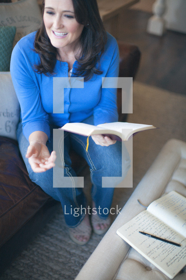 woman holding a Bible and talking at a Bible study