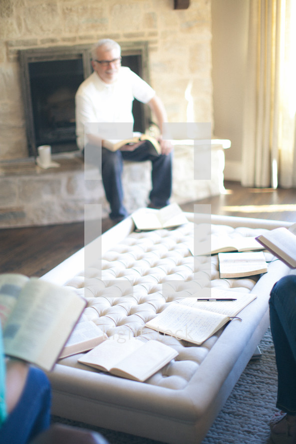 Man sitting on fireplace hearth during Bible study.