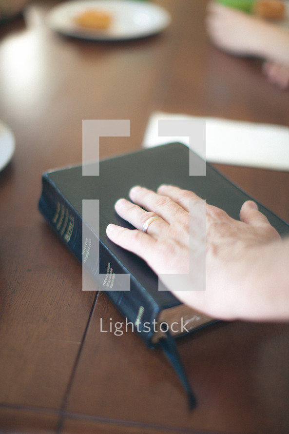 man's hand on a Bible 