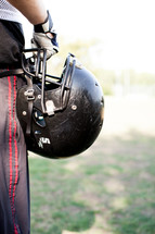 football player holding his helmet 