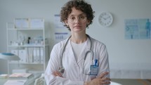 Portrait of Young Female Doctor Posing with Arms Crossed in Clinic
