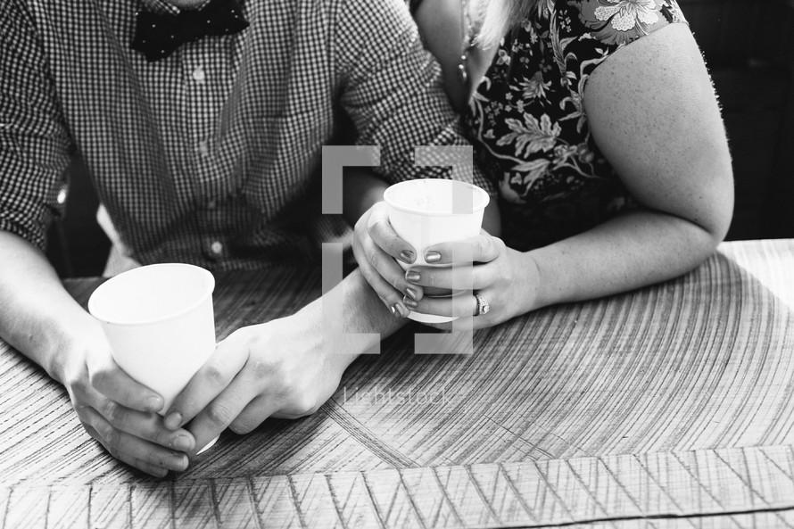 engaged couple snuggling drink cups of water 