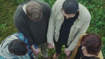 looking down into a group holding hands in prayer 