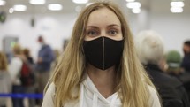 Female traveller in black face mask walking waiting for check in at the airport.