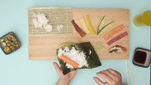 Child preparing sushi roll