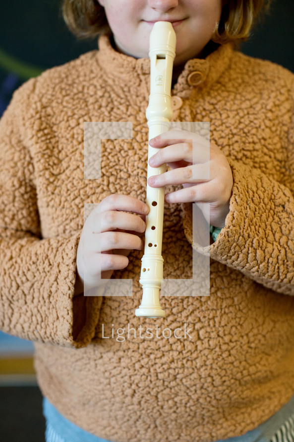 child playing  white recorder 