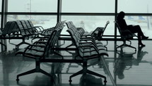 Dolly shot of people walking or having a rest while waiting for their flight in  Airport