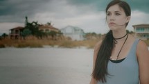 sad girl standing on a beach 
