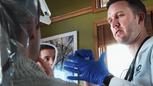 a dentist talking to his patient in an examine room 