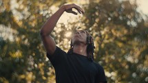 Portrait of a smiling young man playing basketball on a sunny day