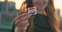 Young women smiling with an ‘I Voted’ stickers and pin 