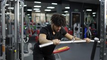 Young man exercising on lateral pull at gym for the back mucles, slow motion.