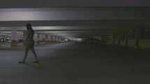 woman walking through a parking garage at night 