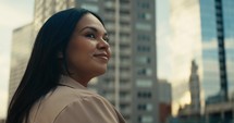 Young woman admiring downtown city buildings and scenery during sunset