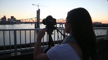 teen girl with a camera on a bridge 