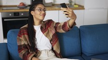 Young beautiful smiling girl with dreadlocks taking selfie picture with smart phone camera.