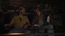 Boyfriend and girlfriend have date at cinema. Love couple watch comedy film.