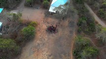 aerial view over a gathered group in a village 